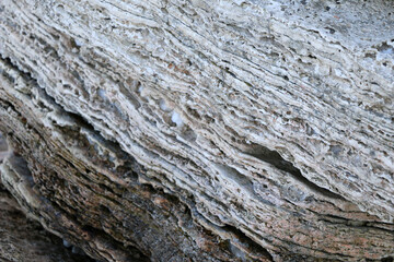 mountain textures of stones with interlayers of gypsum, colored quartz, clay, sand and other layers of various ores, with different textures, color and density, in gypsum ore quarry.
