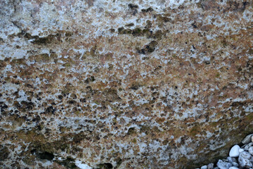 mountain textures of stones with interlayers of gypsum, colored quartz, clay, sand and other layers of various ores, with different textures, color and density, in gypsum ore quarry.