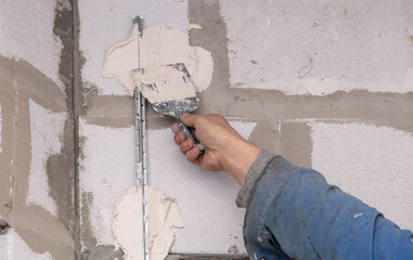 A worker plasters the walls