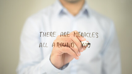 There Are Miracles All Around you, man writing on transparent screen