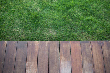 Empty wooden deck with green grass.