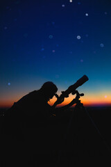 Woman looking at night sky with amateur astronomical telescope.