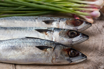 Three Saba Mackerel and Thai cooking ingredients on wooden board and table.