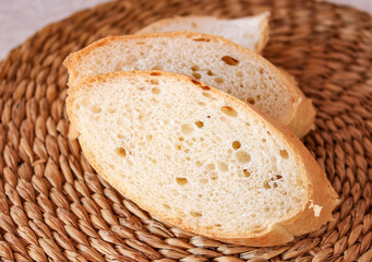 Fresh cut pieces of baguette with seasonings close-up.