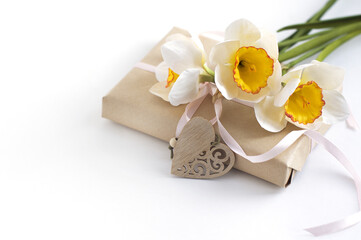 Fototapeta na wymiar gift box, daffodils, carved heart on a white background