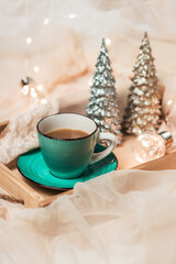 Morning coffee. Cozy winter composition: a cup of coffee and New Year's decor on a silk bed. Life style. Copy space.