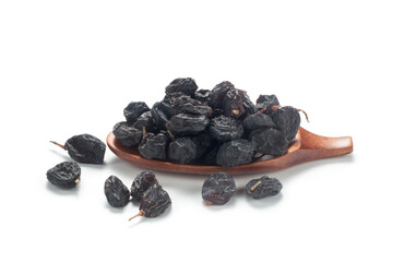 Black currant raisins in a wooden spoon. Isolated on white background.