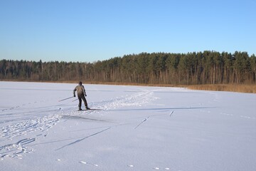 A man skier rides across a snowy field.