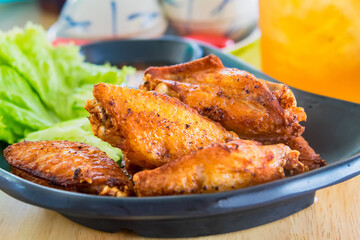 Traditional Thai fired chicken wing close up.