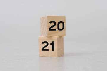 alphabet 2021 new year on wooden cube blocks with cement white background