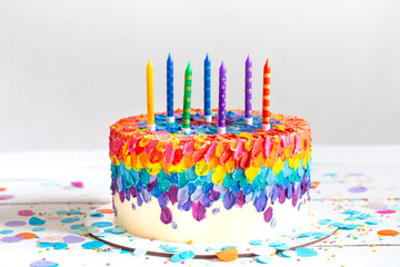 Handmade colorful big birthday cake with multicolored candles.