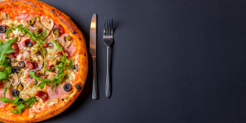 Hot tasty delicious rustic homemade american pizza over black background. Traditional Italian cuisine concept.