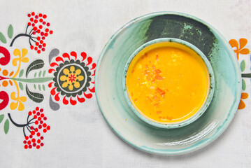 Pumpkin soup with fresh pumpkin seeds served in a bowl over traditional Ukrainian tablecloth. Ukrainian cuisine concept.