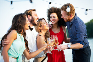 Group of happy friends partying and toasting drinks