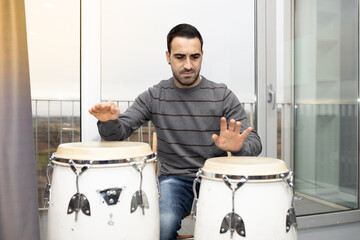 man playing musical instrument percussion congas