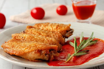 Buffolo wings close-up with tomato sauce and tomatoes