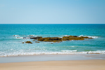 Breaking sea wave with stone on a sandy beach background. Natai Beach, Phang-nga, Thailand, Asia