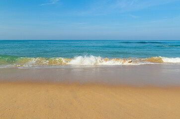 Fototapeta na wymiar Breaking sea wave on a sandy beach background