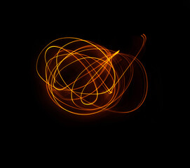 Light wave trail path, vibrant neon gold color in abstract swirls on a black background
