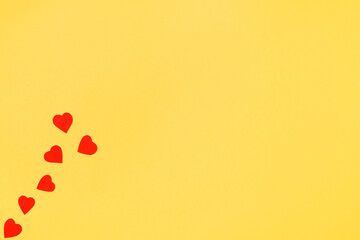 Festive composition with red hearts and yellow background. Flat lay, top view, copy space. Valentine's day concept, wedding, greeting card