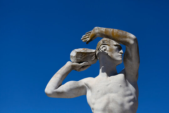 Athlete Marble statue portrait against blue sky.