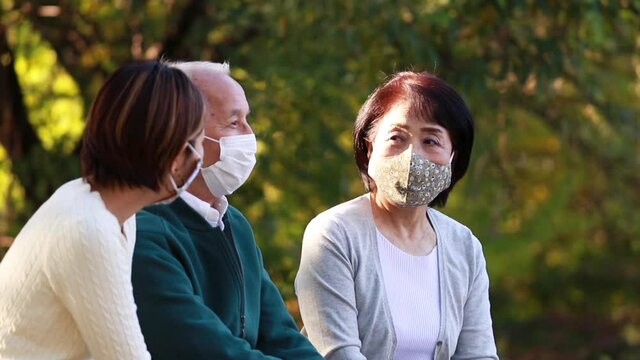 マスクをつけて談笑する日本人親子・二世代家族