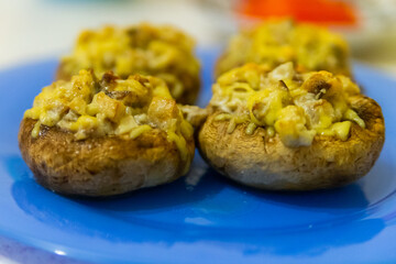 Grilled mushrooms stuffed with cheese on blue plate