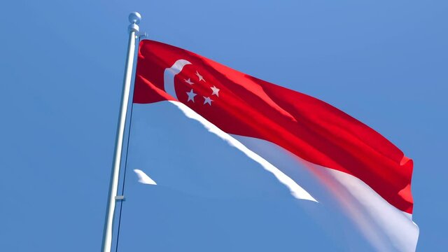 The national flag of Singapore flutters in the wind against a blue sky