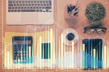 Double exposure of forex chart hologram over desktop with phone. Top view. Mobile trade platform concept.