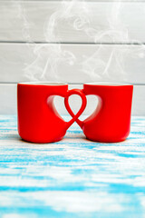two heart shaped mugs with tea on white background

