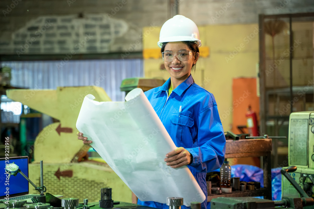 Poster female technician worker working and checking machine in a large industrial factory.
