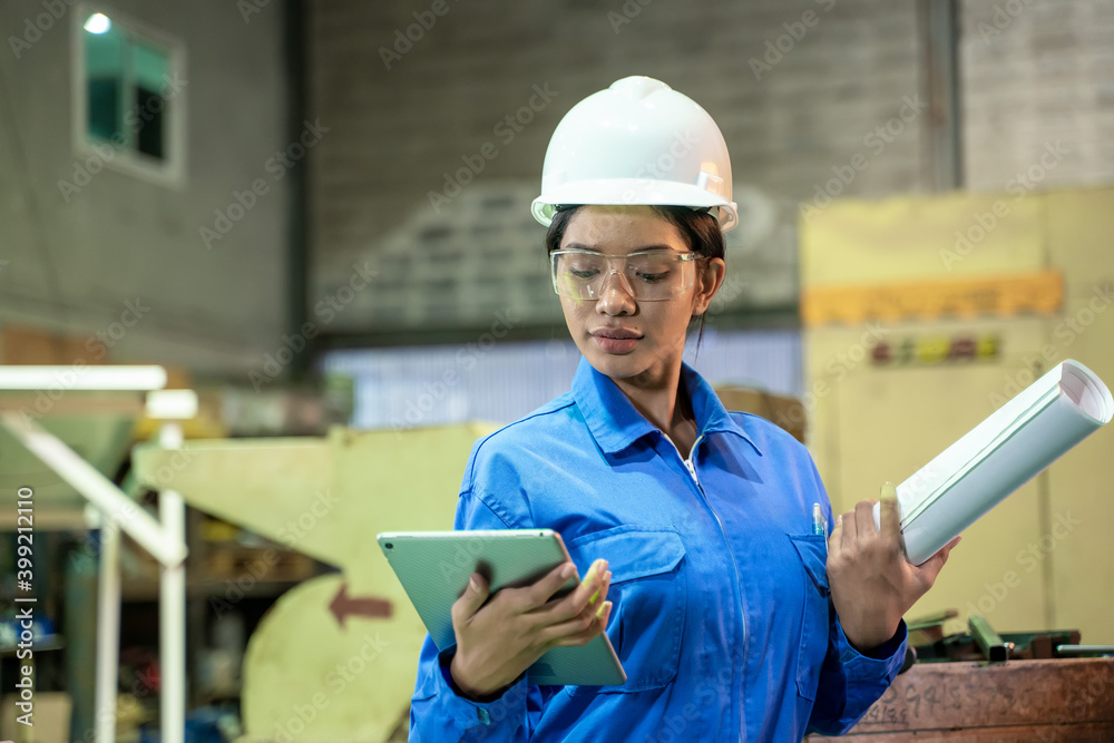 Poster female technician worker working and checking machine in a large industrial factory.
