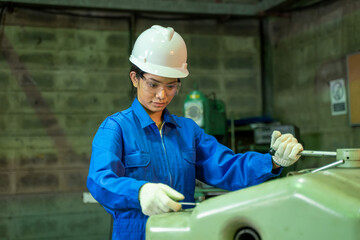 Young female in blue protective uniform working inside industry factory.
