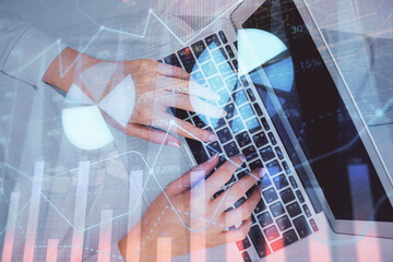 Double exposure of woman hands working on computer and forex chart hologram drawing. Top View. Financial analysis concept.