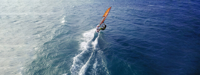 Aerial drone ultra wide top view photo of fit man practising wind surfing in Mediterranean bay with...
