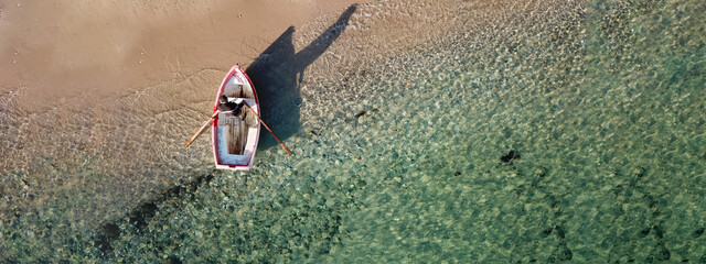 Aerial drone ultra wide photo of small traditional fishing boat near port of Mykonos island in...