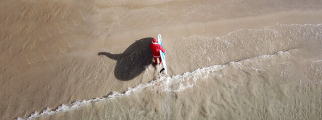 Aerial drone ultra wide panoramic photo of Santa Claus coming out of turquoise exotic sandy beach...