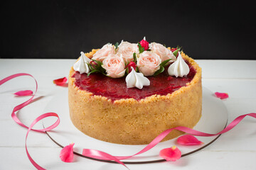 Strawberry cheesecake decorated rose flowers and merinques,  white and black background. Birthday cake, roses cake, ribbon and roses