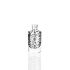 Silver glittering nail polish in glass bottle on white background isolated close up, opened gray sequin varnish, bright shiny grey lacquer, sparkling enamel, beautiful shimmer gel, beauty cosmetic