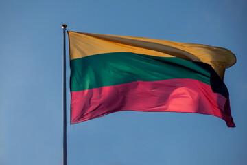 The flag of Lithuania flying against blue sky