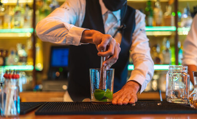 Barman making cocktail at night club