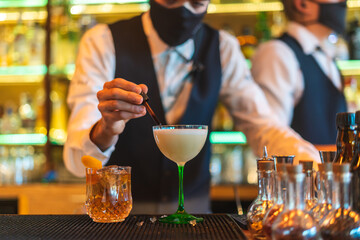 Barman making cocktail at night club