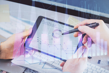 Double exposure of man's hands holding and using a phone and financial chart drawing. Market analysis concept.