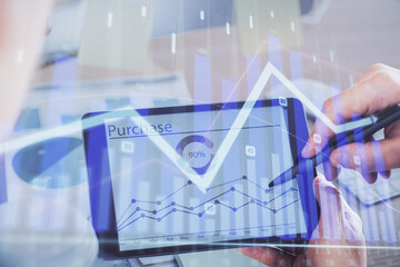Double exposure of man's hands holding and using a phone and financial chart drawing. Market analysis concept.