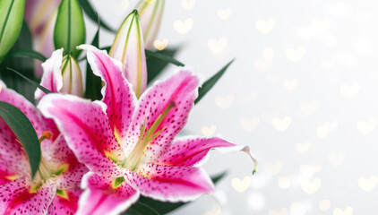 Lily flowers greeting card on heart shaped bokeh background with copy space. Floral banner. Valentines day concept or mothers day.