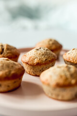 Chocolate banana muffins on a round pink dish, close-up, selective focus