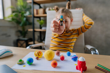 Girl sculpts planets models from kids clay © lithiumphoto