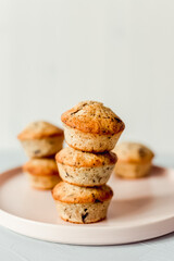 Chocolate banana muffins on a round pink dish, close-up, selective focus