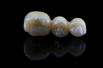 three dental crowns made of zircon on a black background