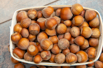Hazelnuts in small crate on rustic background